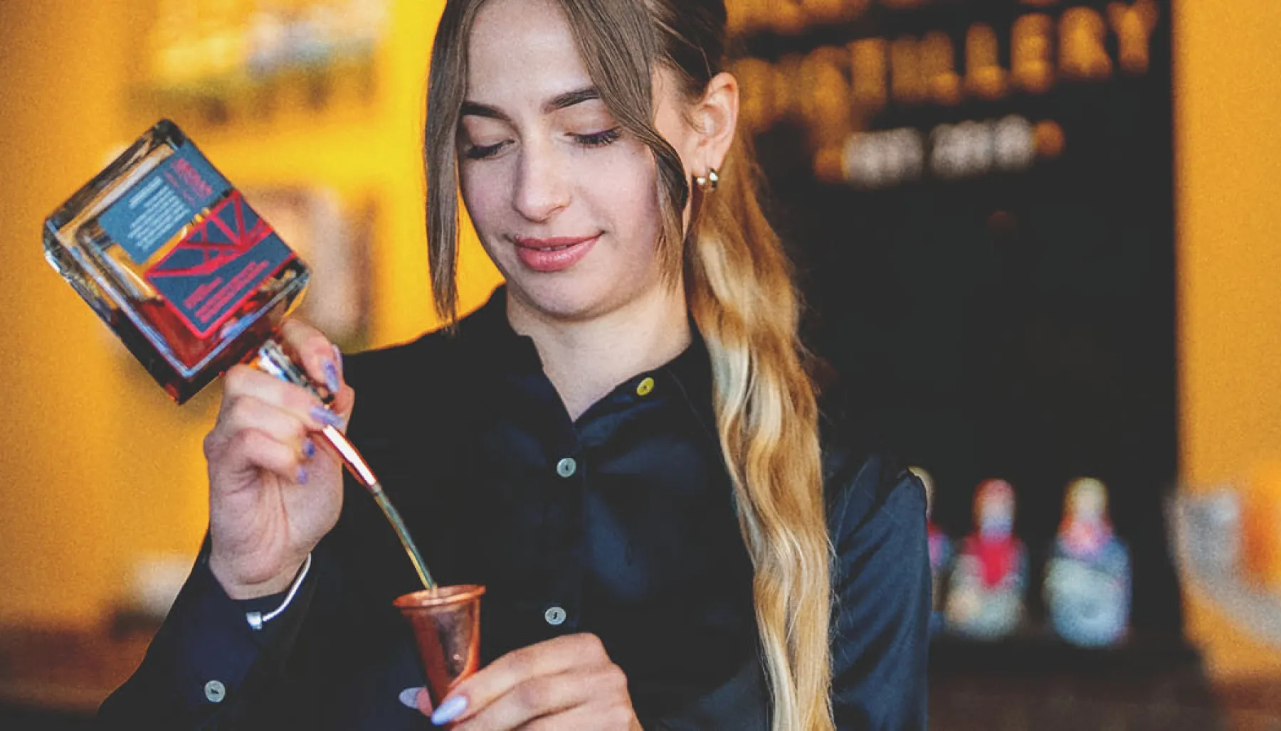 Mixologist pouring alcohol at Bridgeland Distillery