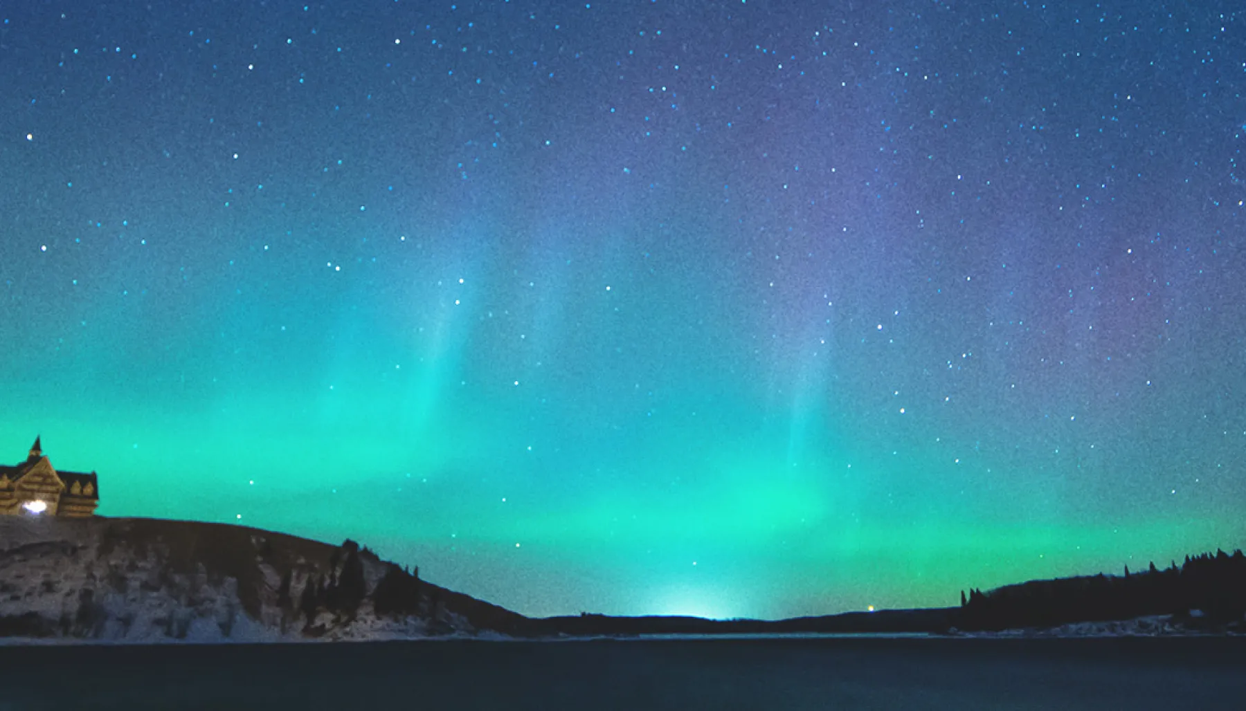 The Northern Lights shine brightly above Prince of Wales Hotel in Waterton Lakes National Park at night