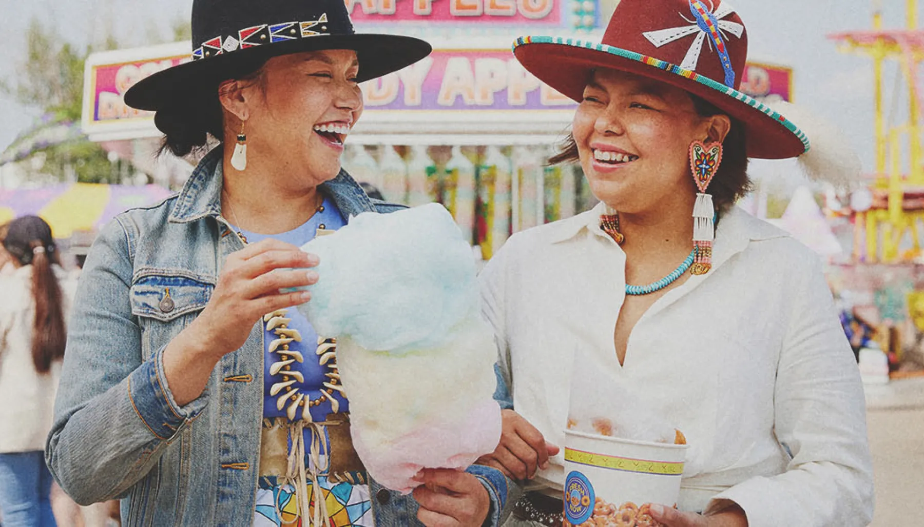 two Indigenous ladies enjoying some classic midway food at Calgary Stampede