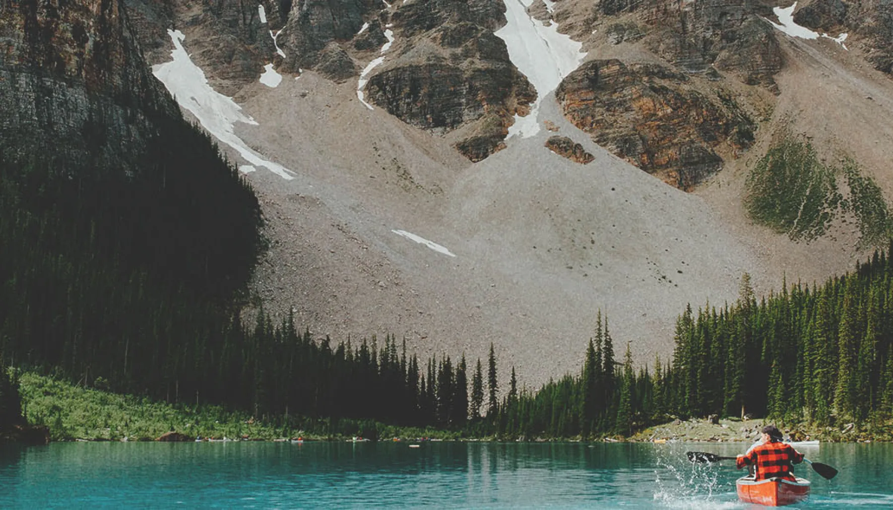 Person in a canoe on Moraine Lake surrounded by mountains in Banff National Park