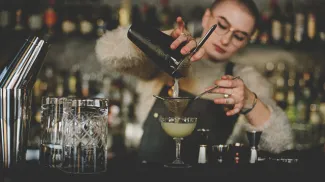 Bartender at Proof pouring a cocktail