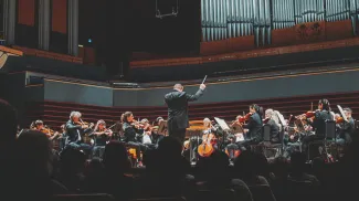 a full crowd of spectators enjoying a performance by the Calgary Philharmonic Orchestra