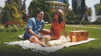 couple enjoying a picnic in the grass in a park in downtown Calgary