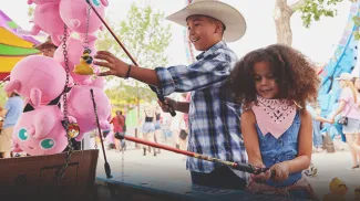 two children playing games at the Calgary Stampede Midway
