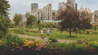 couple walking their dog through Prince's Island Park during summer