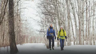 two friend hiking through Fish Creek Provincial Park in winter