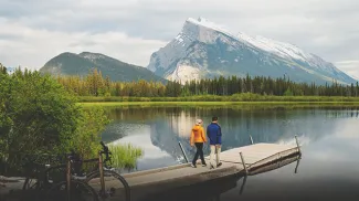 Couple walking on dock after riding bikes at Vermillion Lakes in Banff