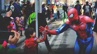a little boy giving a spiderman a high five at the Calgary expo