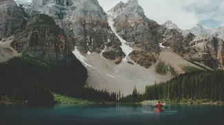 Person in a canoe on Moraine Lake surrounded by mountains in Banff National Park