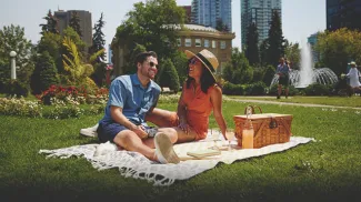 couple laughing and enjoying picnic at Central Memorial Park in Calgary