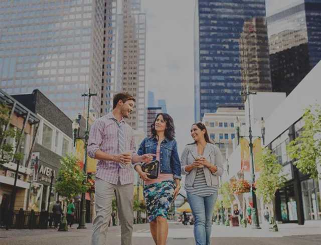 three people walking along Stephen Avenue in downtown Calgary