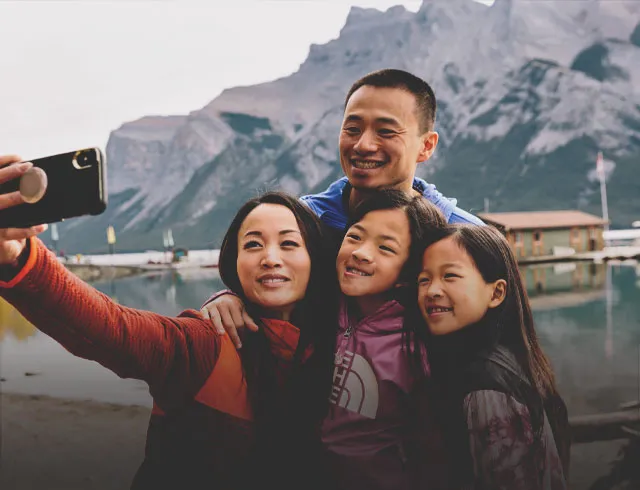 Family posing for a selfie in front of a mountain in Banff National Park