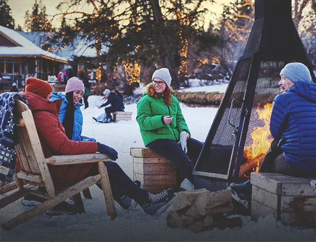 friends warming up around a fire while skating in Bowness park
