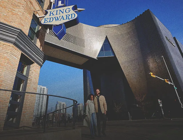 couple walking in east village underneath Studio Bell and the historic King Eddy sign