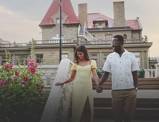 couple holding hand and smiling in front of the Lougheed House