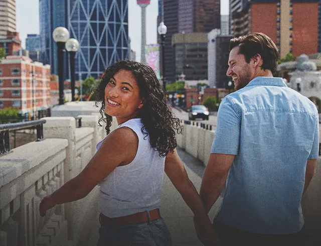 a couple holding hand and smiling on the bridge