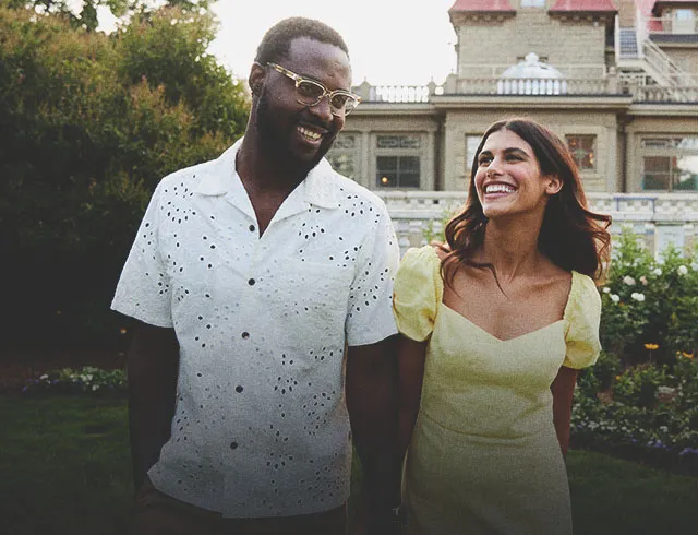 couple holding hands in front of Lougheed House