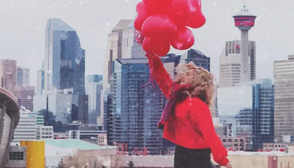 Red balloons in front of the Calgary skyline