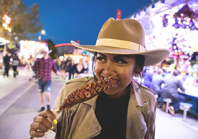 woman eating a tentacle in the Stampede Midway