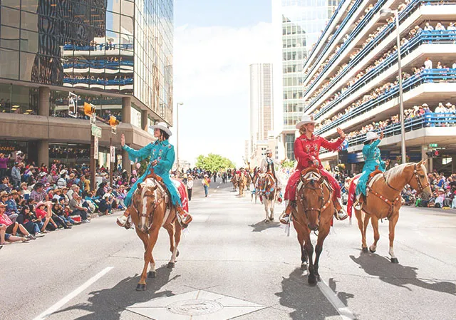 two rodeo queens riding horses in the Stampede parade through downtown Calgary