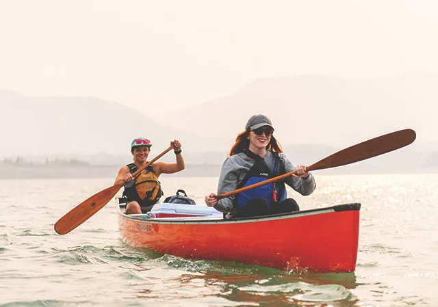 two women paddling in a red canoe on Barrier Lake