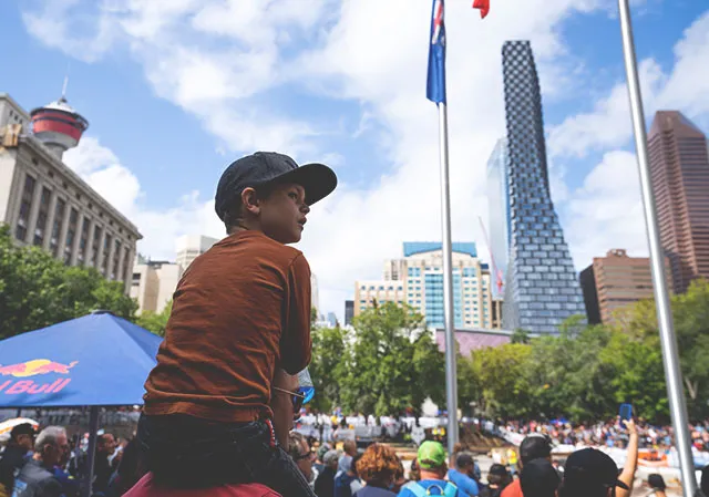 Child on his parents shoulders watching Red Bull Outliers