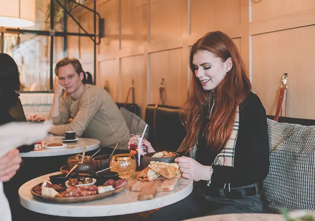 Woman eating at a table in Distilled Beauty Bar