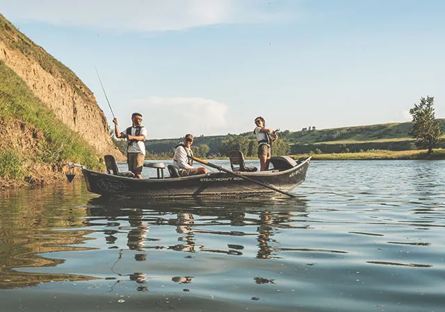 Three gents stand in a fly fishing boat with Drift Out West Flyfishing