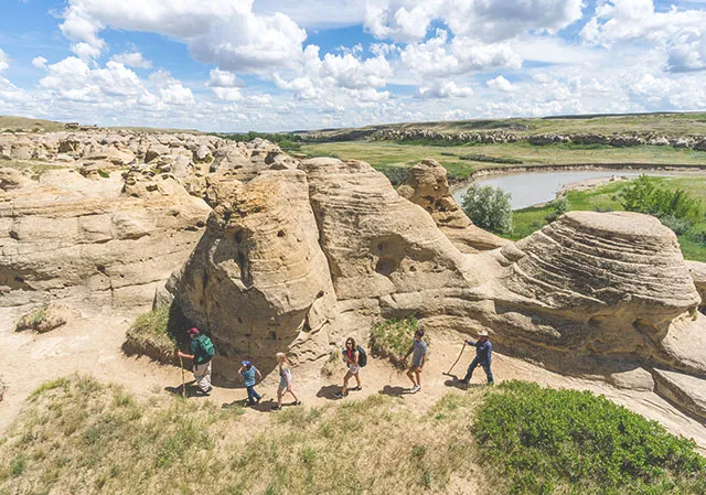 Group hiking through hoodoos at Writing-on-Stone Provincial Park