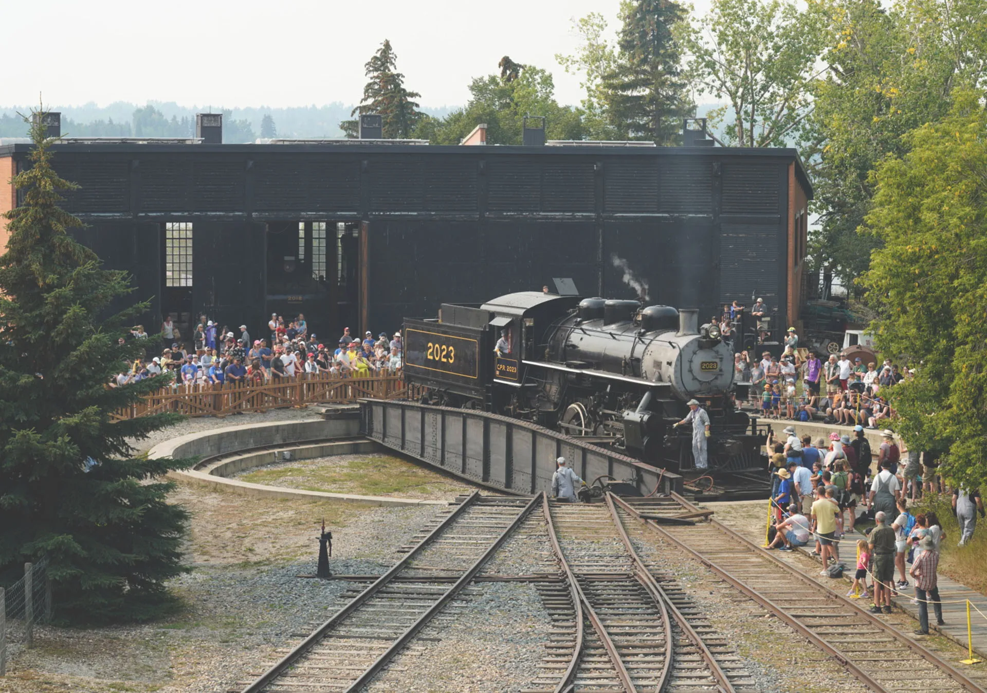 Crowd surrounding steam engine on railway Turntable at Heritage Park