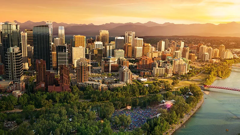 aerial of downtown Calgary, the Bow River, and Prince's Island Park during Folk Fest at sunset