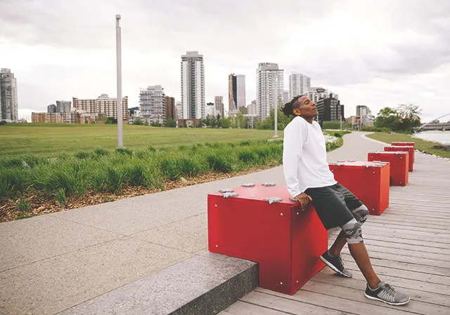 man taking a break from walking along the RiverWalk in East Village with the skyline in the background