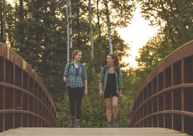 two women walking along a bridge in Fish Creek Park