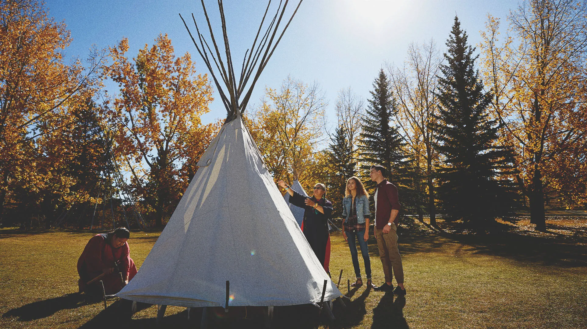 People learning how to set up a tipi at Heritage Park