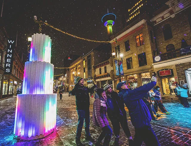 group posing with a Chinook Blast art installation along Calgary's Stephen Avenue