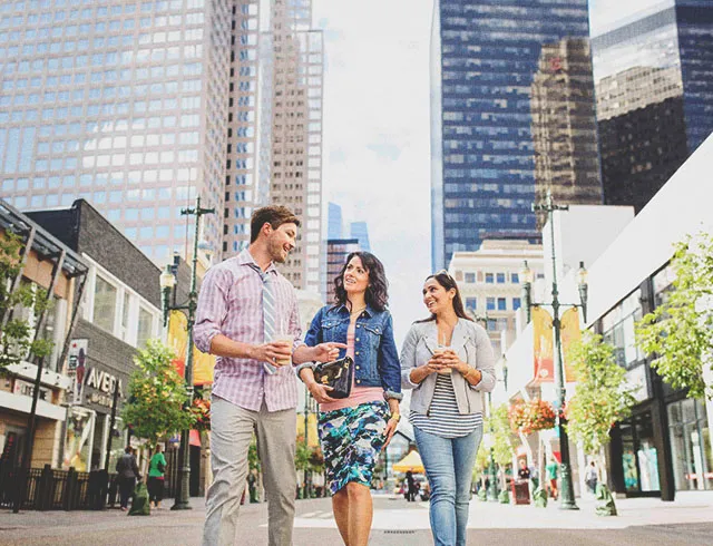 Three colleagues walking along Calgary's Stephen Avenue during summer