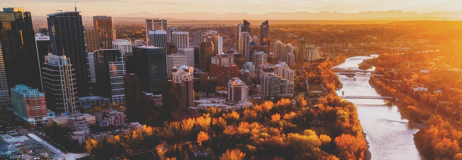 skyline view of downtown Calgary and the Bow River in autumn during sunset