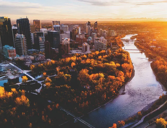 skyline view of downtown Calgary and the Bow River in autumn during sunset