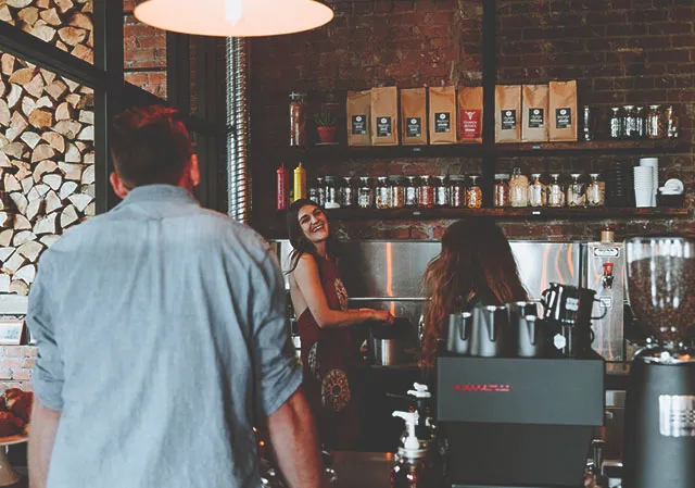 Man ordering coffee at a counter within Calgary Heritage Roasting Company