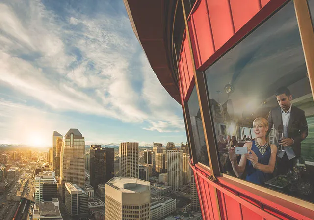 exterior shot of Sky360 restaurant at the top of the Calgary Tower with a couple looking out