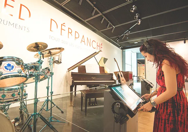 woman interacting with a musical exhibit at Studio Bell