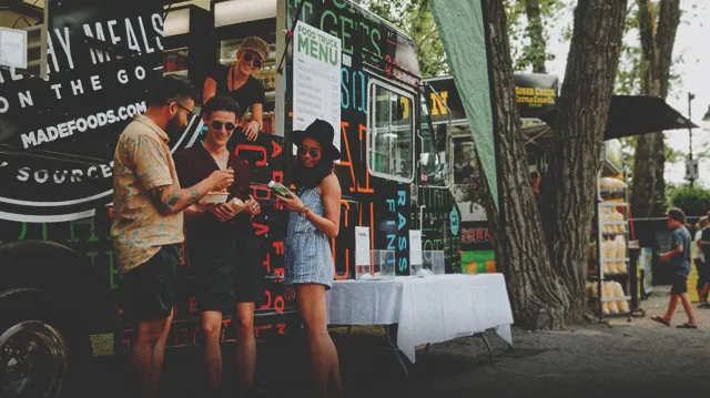 friends ordering from a food truck at Folk Fest