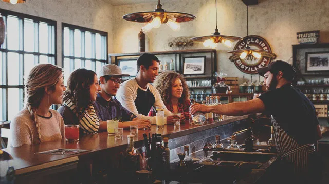 group enjoying a spirit sampling at the bartop of Eau Claire Distillery