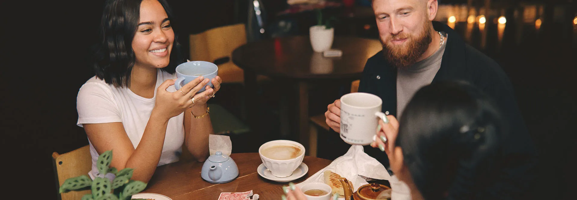 friends sipping tea and coffee while playing cards at a table at Congress Coffee