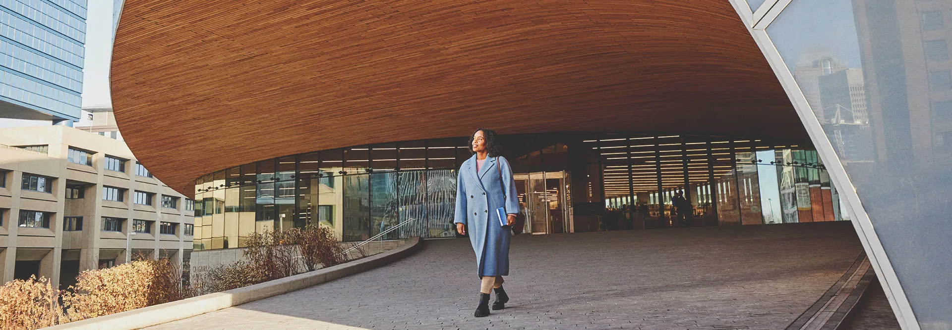 woman walking outdoors in front of Calgary Central Library