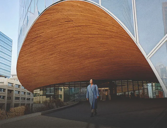 woman walking outdoors in front of Calgary Central Library