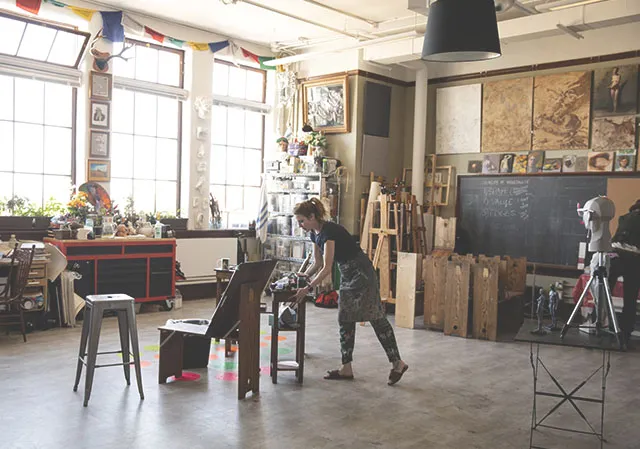 woman preparing an art space at cSPACE Marda Loop