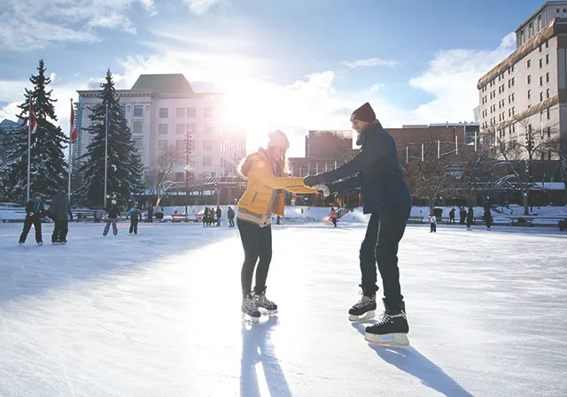 couple learning to skate at Olympic Plaza in downtown Calgary