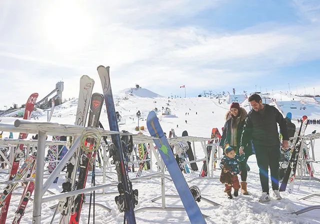 family exploring the ski hill at WinSport
