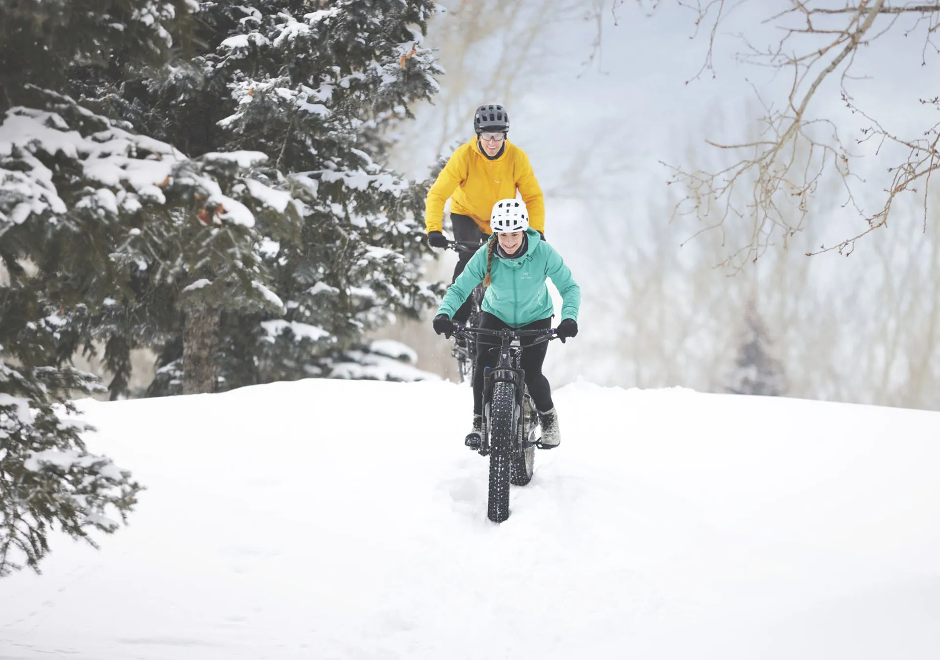 man and woman fat biking during winter in a park in central Calgary